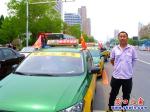 一排愛(ài)心送考的士在營(yíng)口市三高門(mén)前免費(fèi)送考生